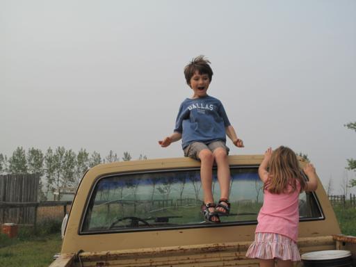 two kids at the back of the old farm truck