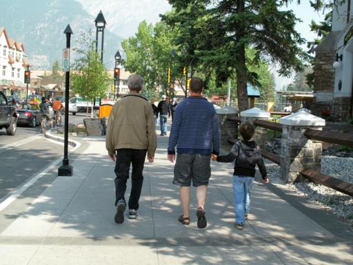two men with a little boy walking in the pathway