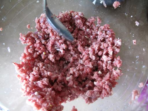 mixing the other ingredients with the Ground steak using a spoon