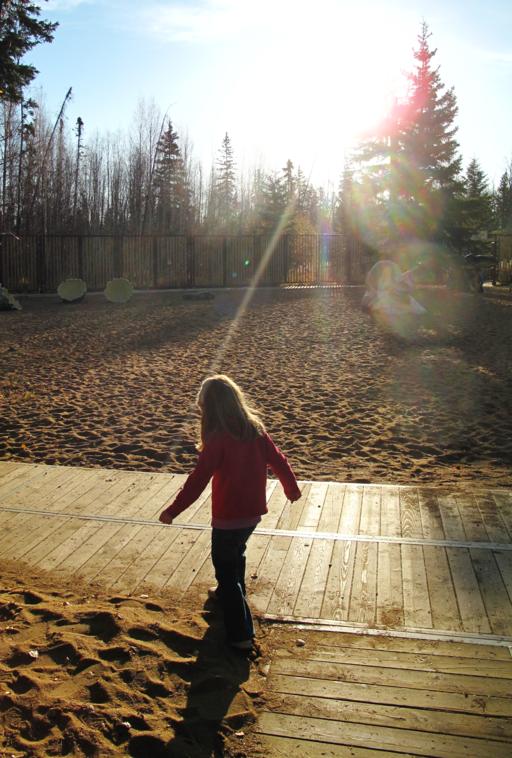 little girl walking in the wooden path