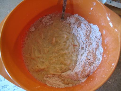 Mixing together dry and wet ingredients in large orange bowl for Apple Pie Pancakes
