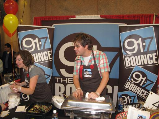 91.7 bounce booth with a man and woman serving food