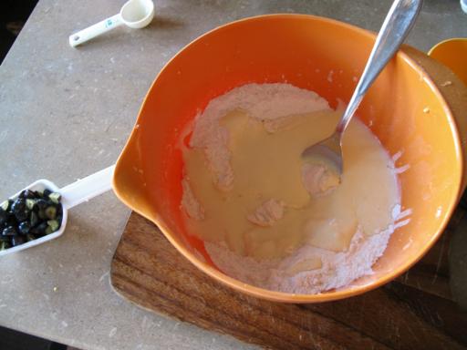 Combining the yogurt, melted butter, lemon juice and egg in an orange bowl