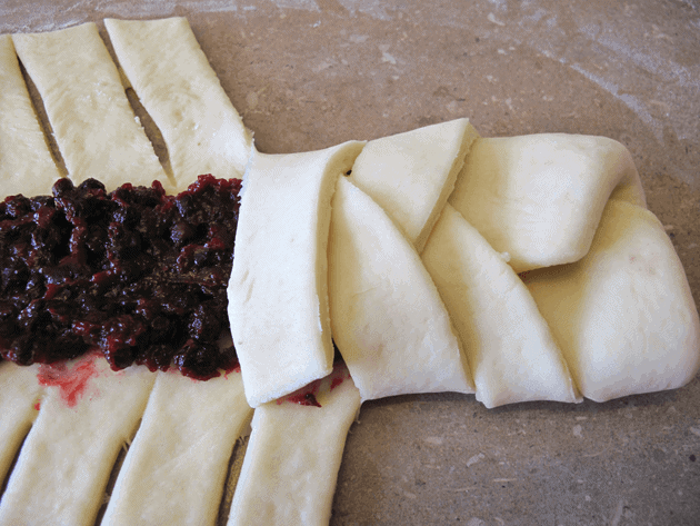 folding the dough criss-cross on a fruit bread braid