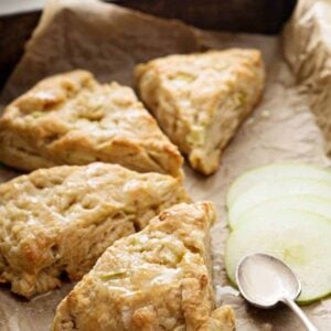 close up glazed pie shape Apple Scones with slices of tart apples on side