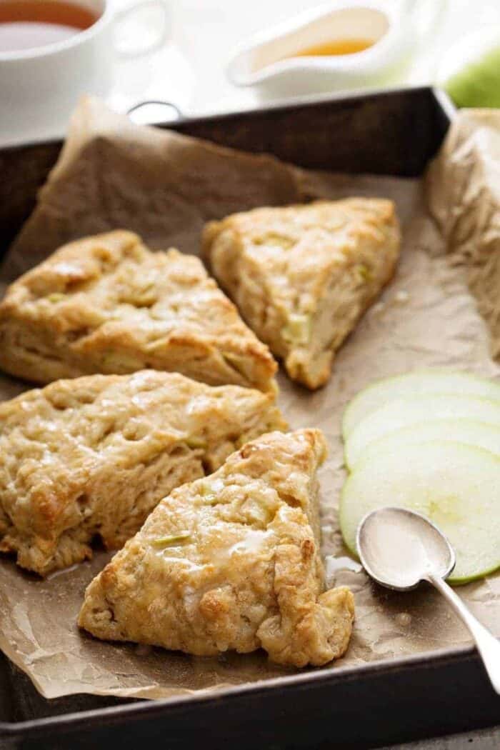 close up glazed pie shape Apple Scones with slices of tart apples on side