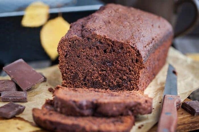 Chocolate Zucchini Bread, some chocolate chips and a bread knife on background 