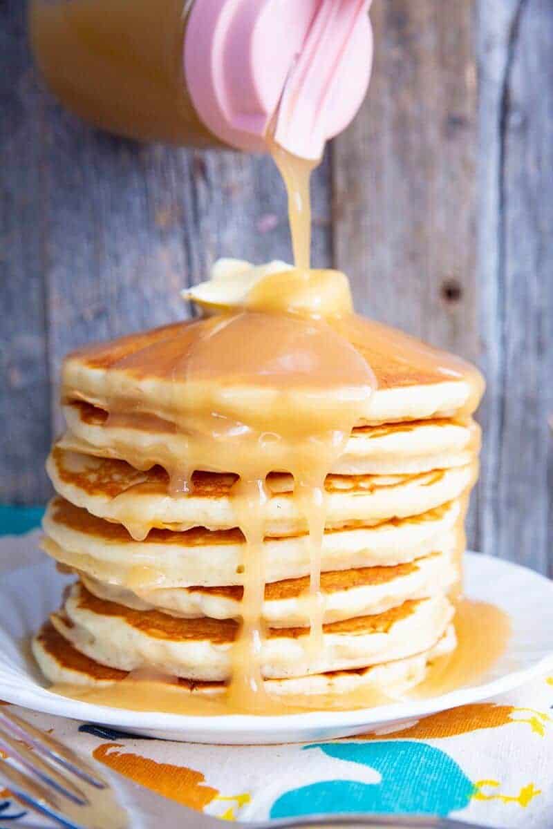 Close up of brown sugar sauce poured on a stack of hotcake with butter on top