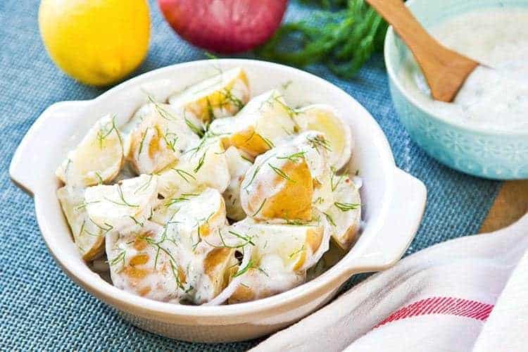 Ukrainian Style Cream Dill Potatoes in a pink bowl and all its ingredients on blue background