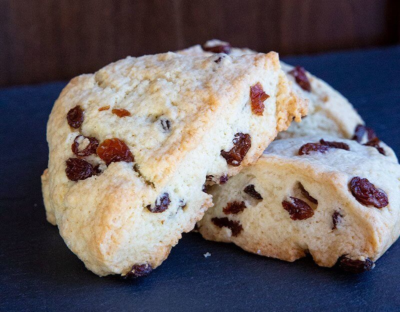 buttery scones with raisins on blue background