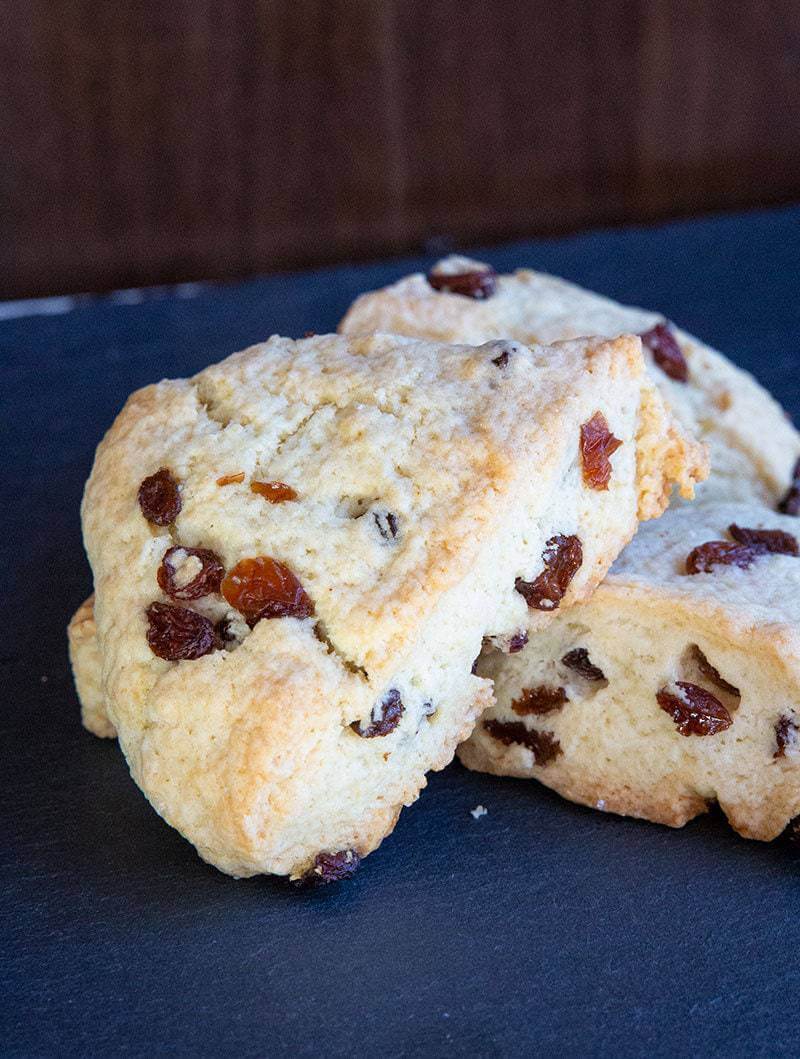 close up of scones with raisins on blue background