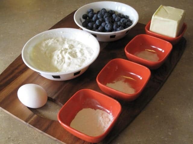 ingredients needed for scones in red and white bowls on wood board