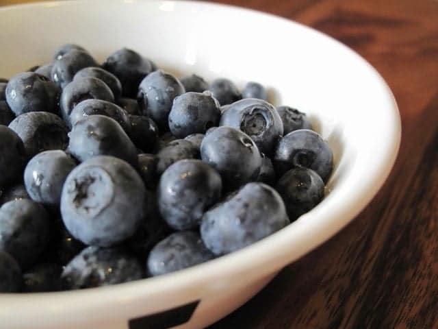 close up of blueberries for scones in a white bowl