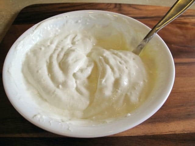 a spoon in bowl with sour cream