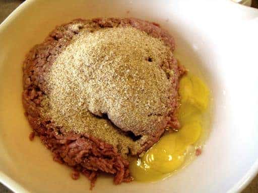 combining breadcrumbs, egg and ground beef together in a bowl