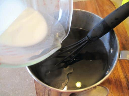 adding the flour and cold water mixture to the sauce