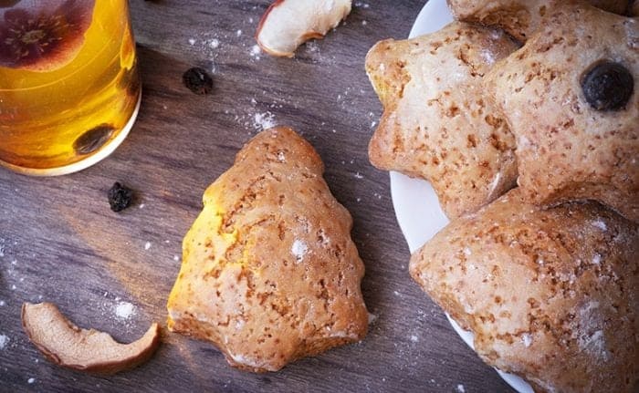 a plate of Ginger scones cut into adorable Christmas shapes! A glass of ginger tea on the side