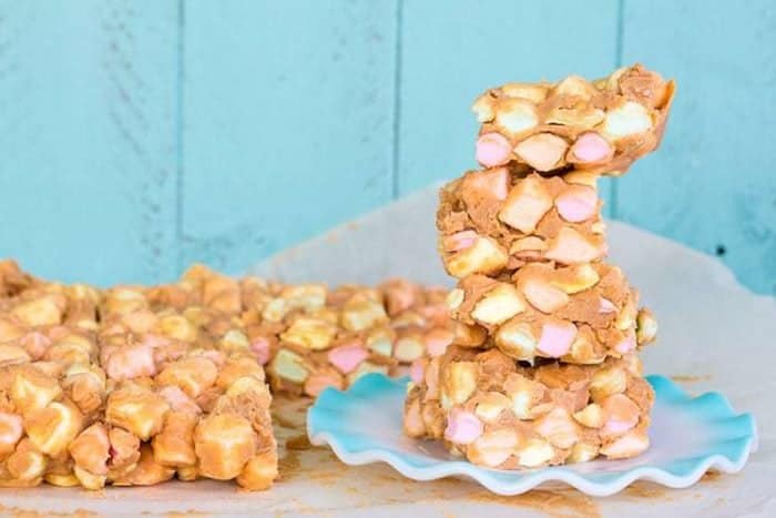 No Bake Peanut Butter Colored Marshmallow Squares on jade blue background