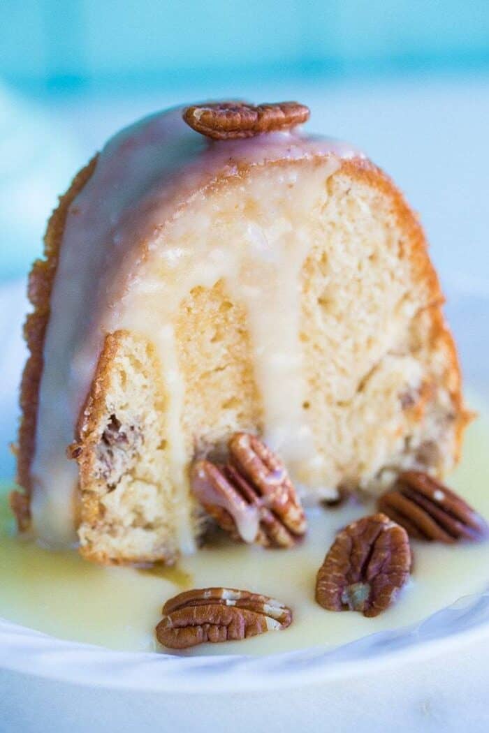 glazed slice of Pecan Butter Rum Cake topped with some pecans