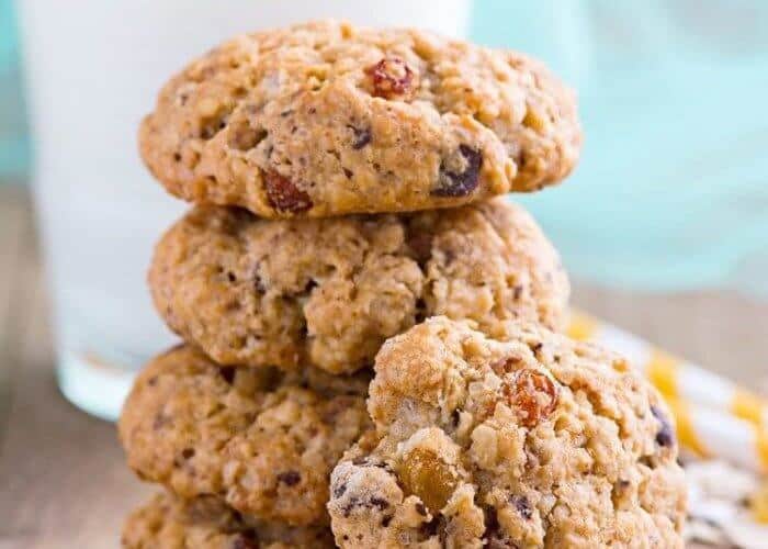 close up stack of Spicy Oatmeal Raisin Cookies with a glass of milk on background