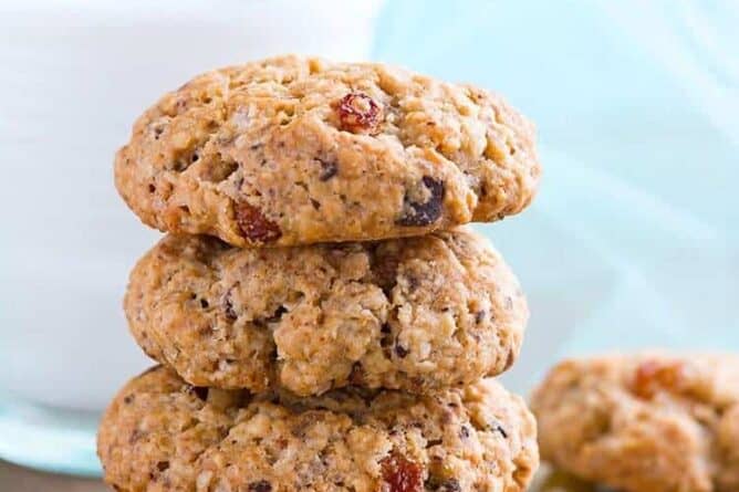 stack of Spicy Oatmeal Raisin Cookies with a glass of milk on background