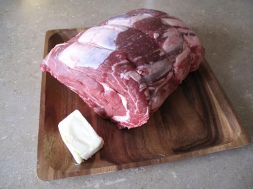 Ingredients in a wooden tray - prime rib roast and butter