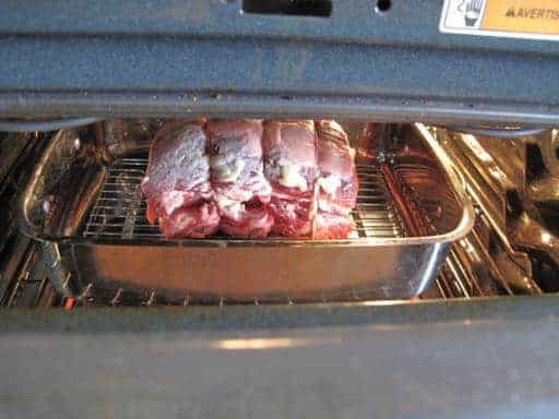 Prime Rib roast in a wire rack with a pan inside the oven