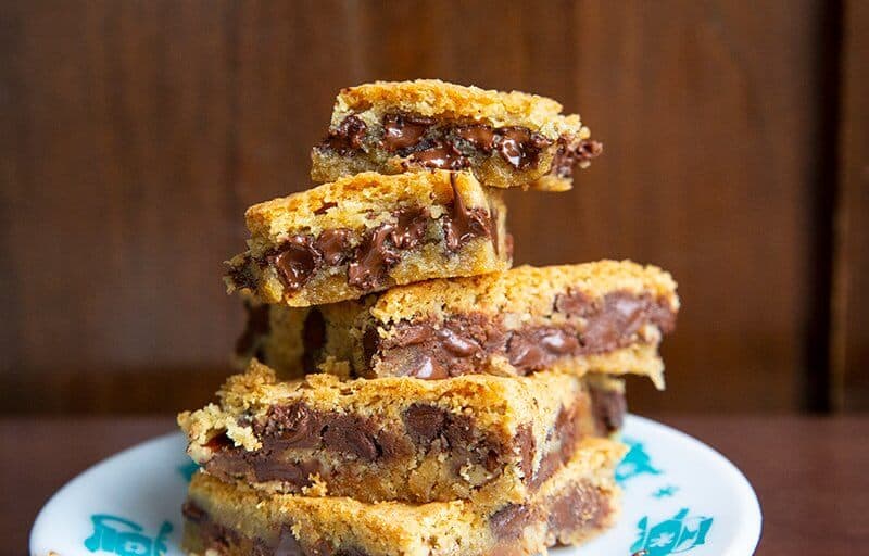 stack of Chocolate Chip Cookie Bars in a dessert plate on brown wood background