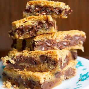 stack of Chocolate Chip Cookie Bars in a dessert plate on brown wood background