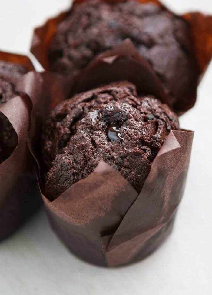 close up Chocolate Zucchini Cupcakes with brown cupcake liners on white background