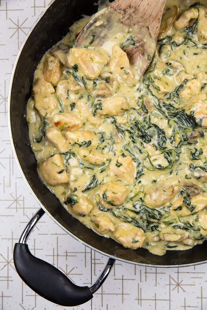 Chicken Florentine with creamy sauce in a black large skillet pan