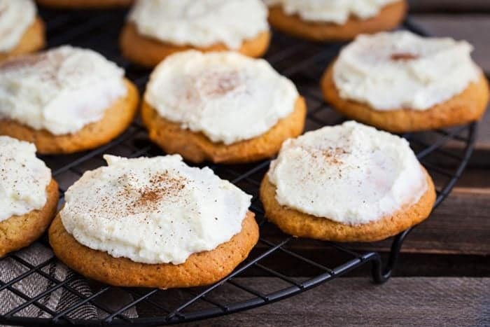 Frosted Pumpkin Drop Cakes on a black cooling rack