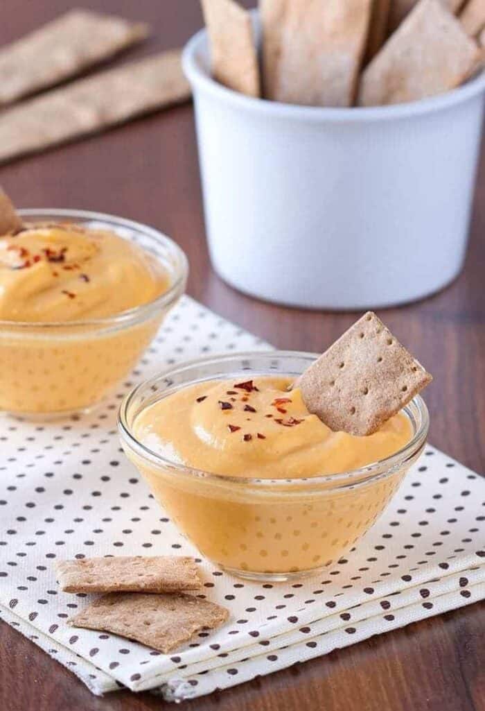 Pumpkin dip made with cream cheese, some graham crackers on background 
