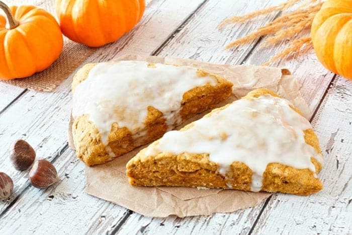 2 slices of glazed Pumpkin Scones on wood background 