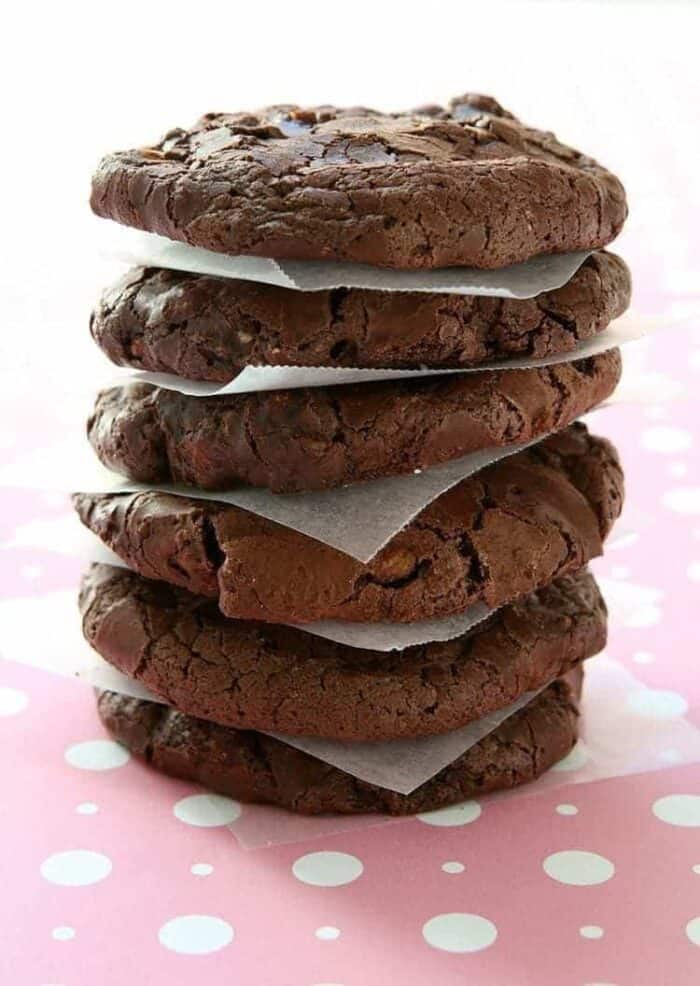 stack of White Chocolate Cocoa Cookies with parchment paper in between each piece