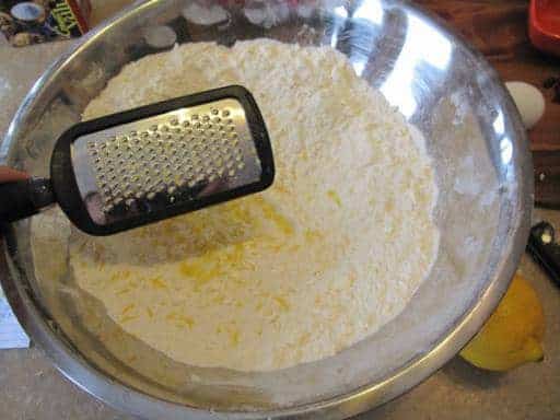 grating the lemon peel into the flour mixture