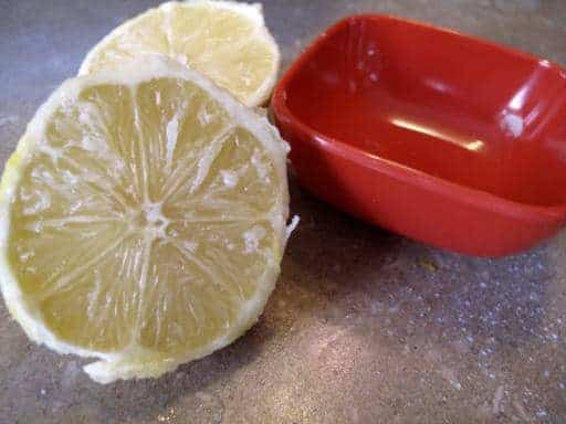 red container and fresh lemon cut into half, squeezed and juice out 