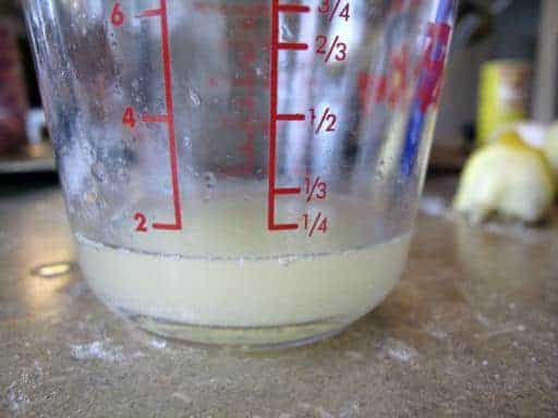 almost a ¼ cup of lemon juice in a Pyrex measuring cup