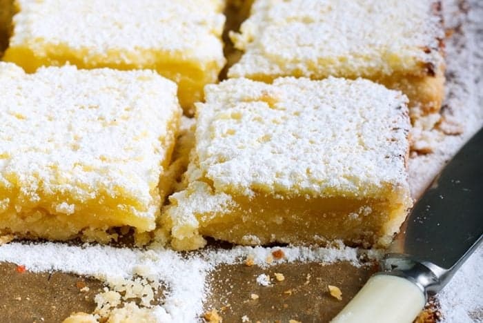 slices of lemon bars sprinkled with icing sugar in a buttery shortbread crust 