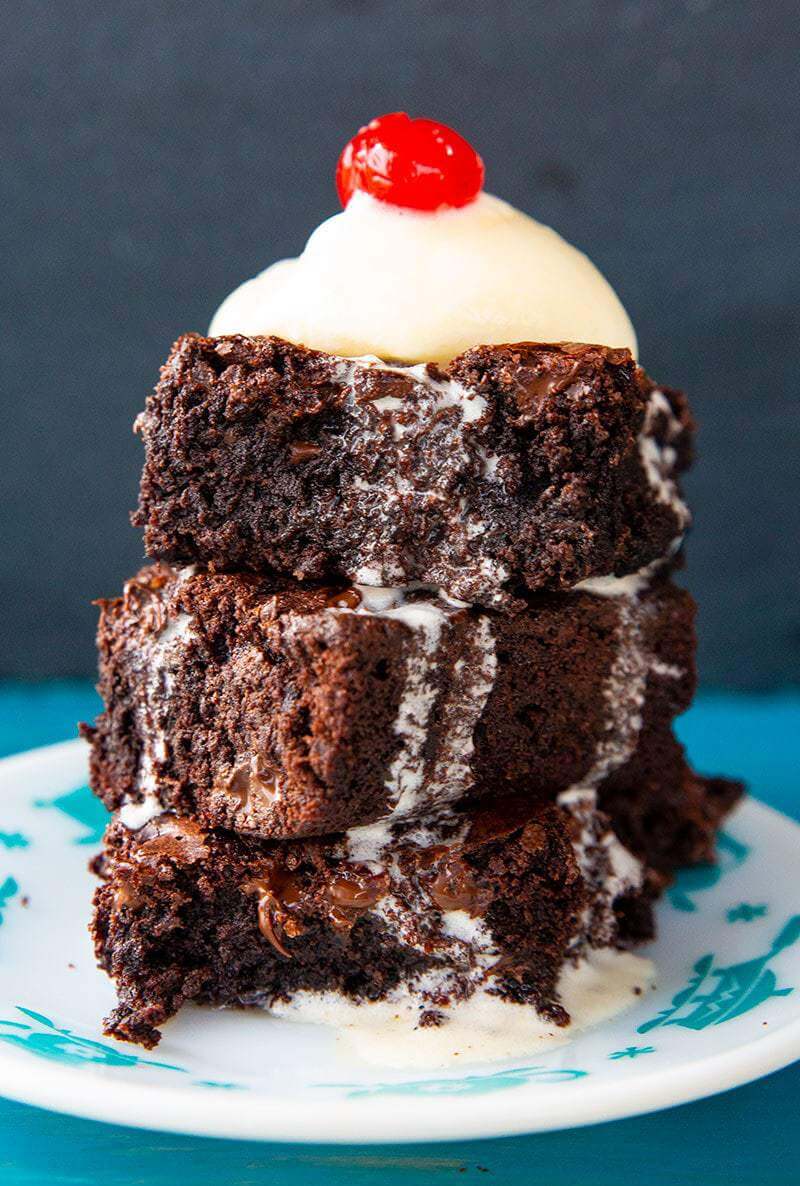 stack of Brownie Topped With Vanilla Ice Cream and a Cherry