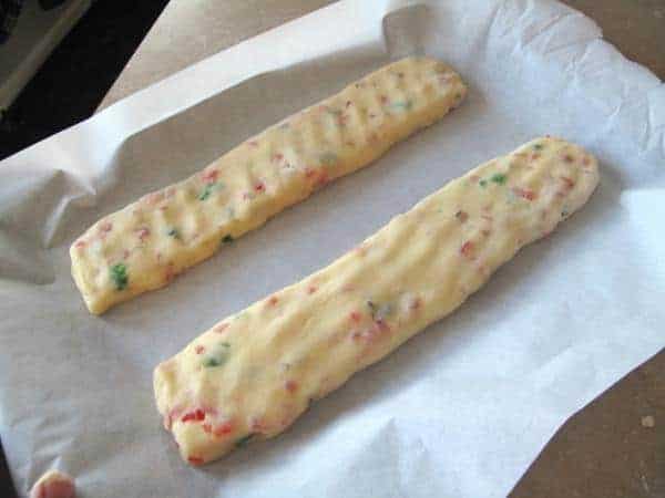 flattened log shaped dough in a baking sheet covered with parchment paper