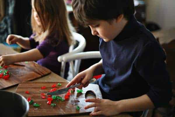 adorable children are chopping the candied cherries and pineapple rounds