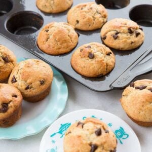 Banana muffins in a dark muffin tin and on a blue ruffled plate