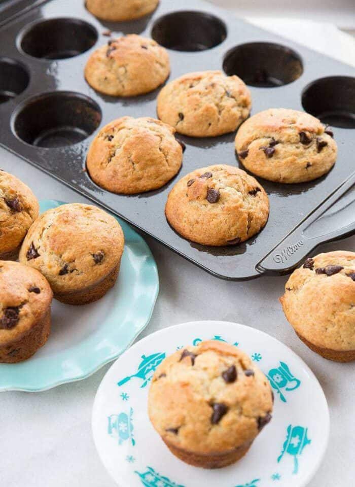 Banana muffins in a dark muffin tin and on a blue ruffled plate 