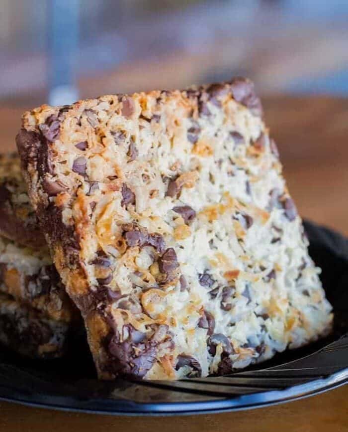 close up slice of Seven layer bars loaded with pecans, chocolate chips and shredded coconut