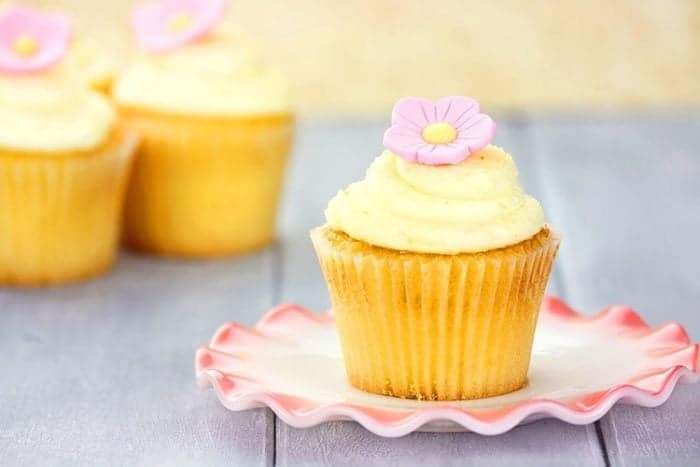 lemon blueberry coffee cupcake topped with Lemon Buttercream Frosting and pink flower icing