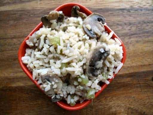 non-creamy version of Rice & Mushroom Casserole in a red bowl on wood background