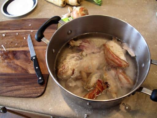 Large pot with water, chicken and bacon ready to be boiled