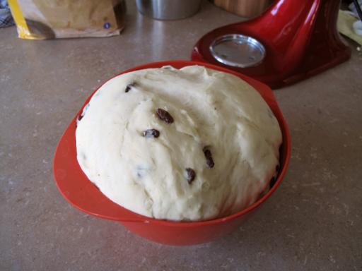 Babka dough risen over the top of the red bowl