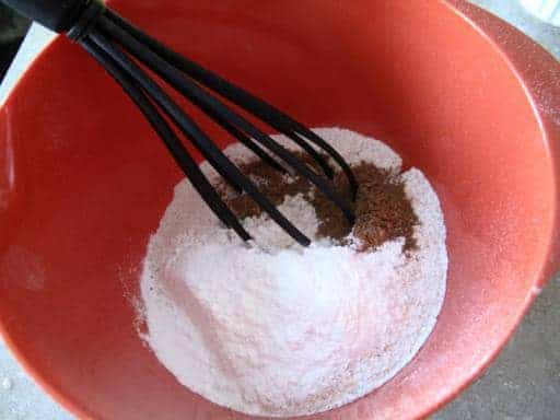 whisking together all the dry ingredients in a large red bowl